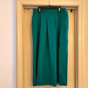 Green pleated skirt. 2 front pockets. 1 button closures